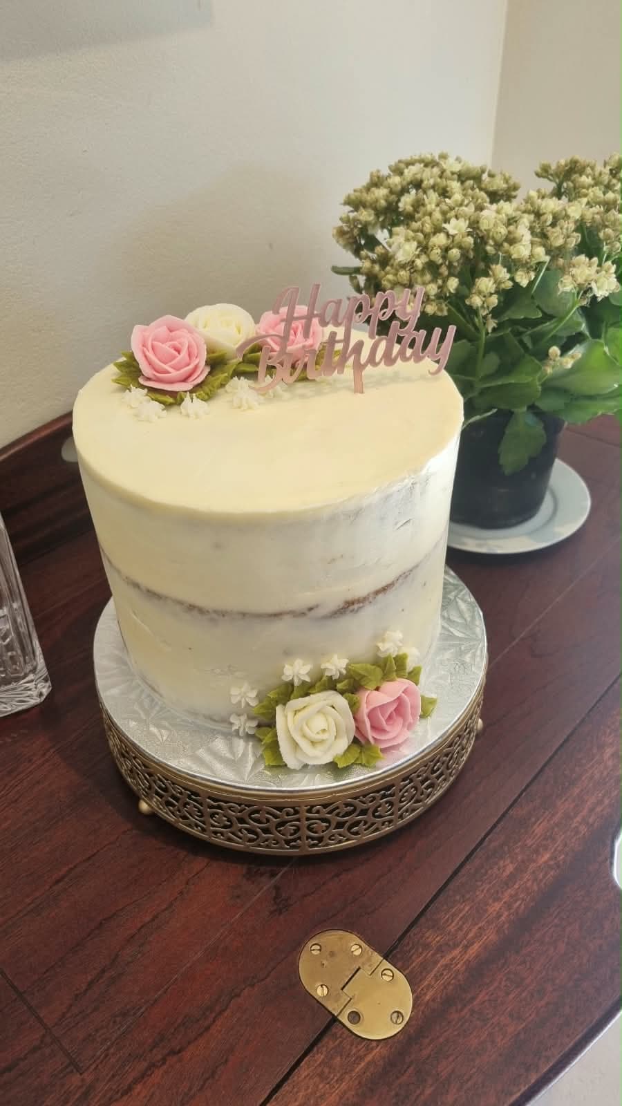 Buttercream celebration cake with piped roses and a Happy Birthday topper