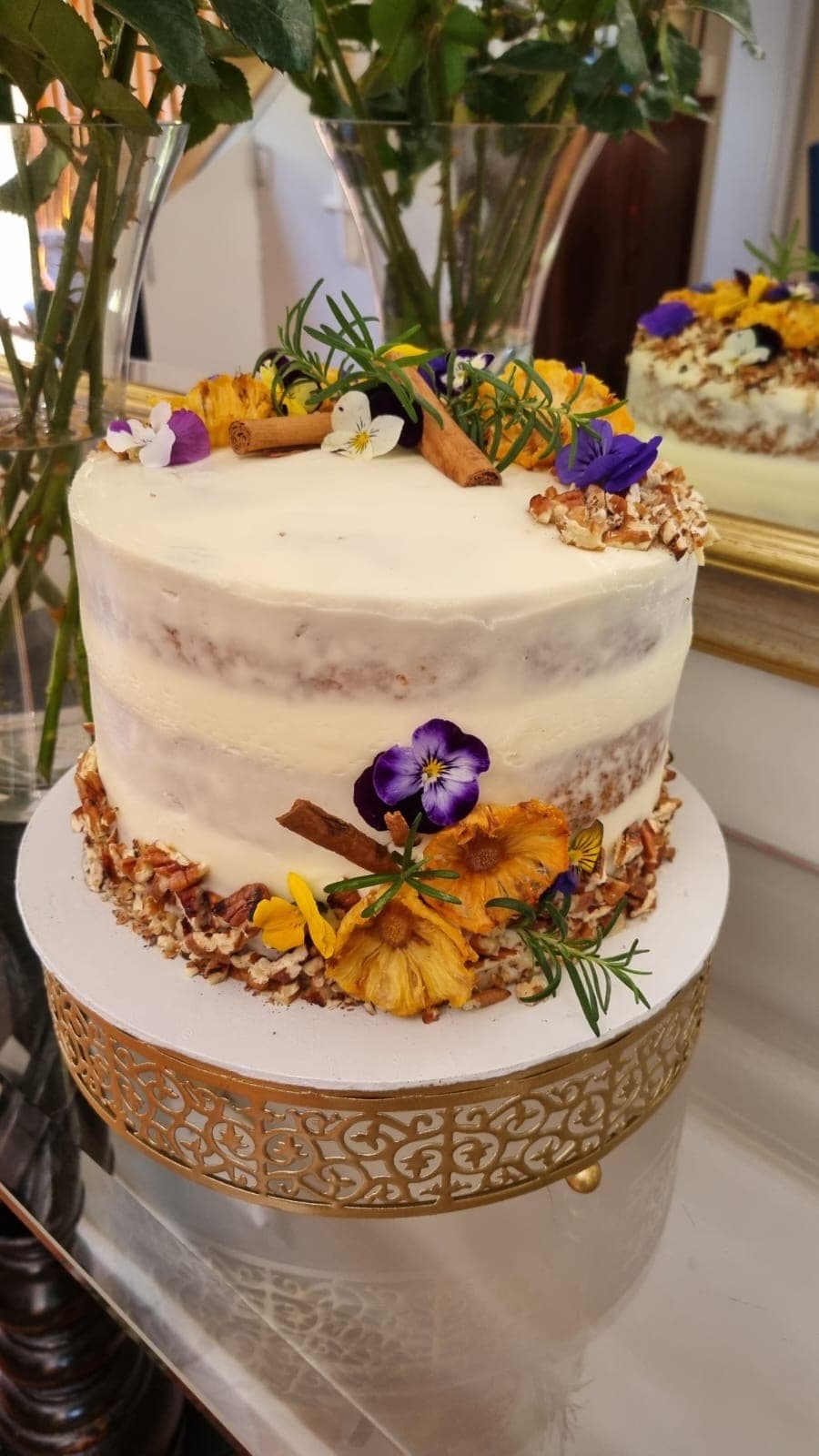 Semi-naked cake decorated with edible flowers and herbs