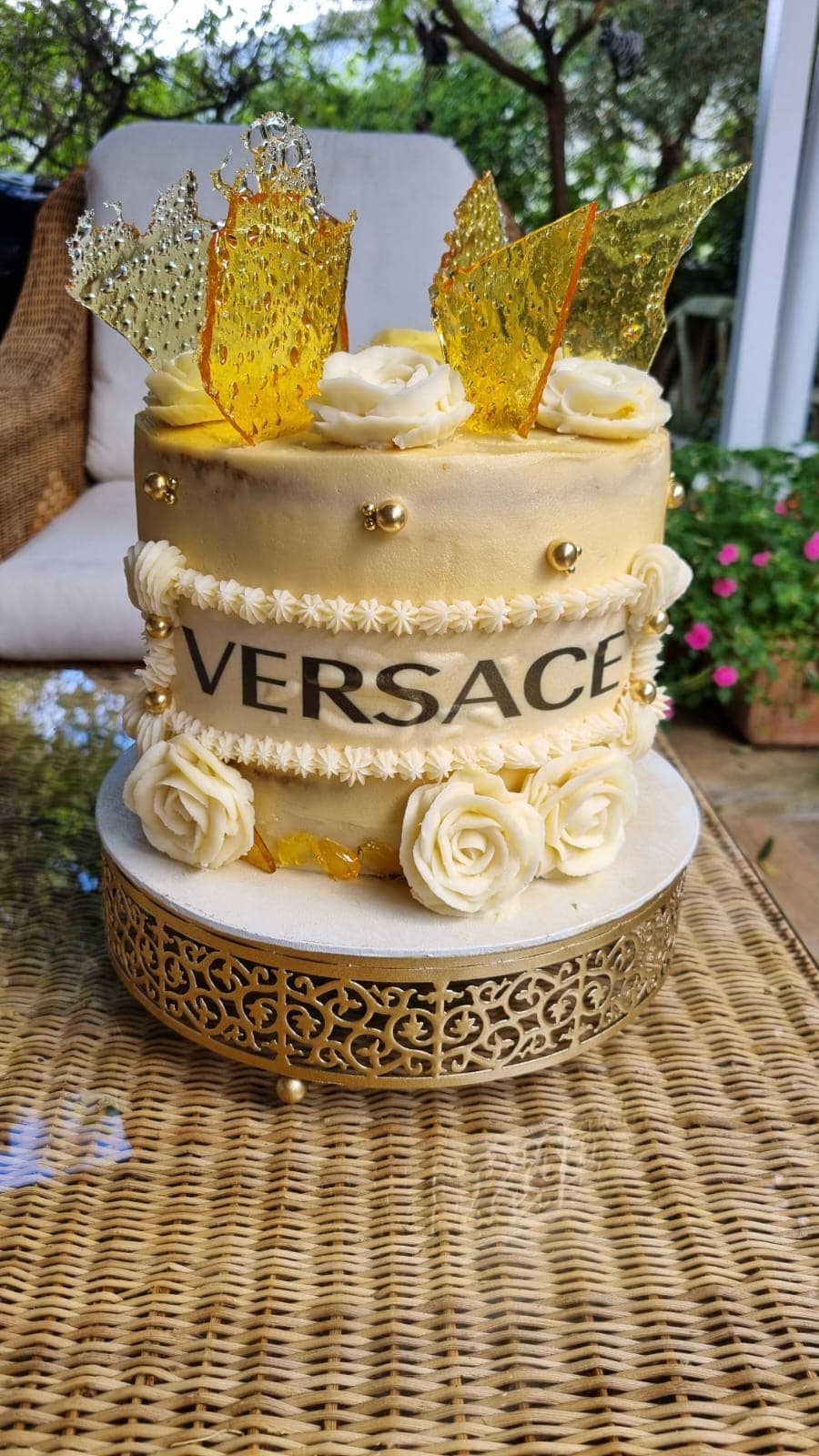 Custom gold themed celebration cake with buttercream roses